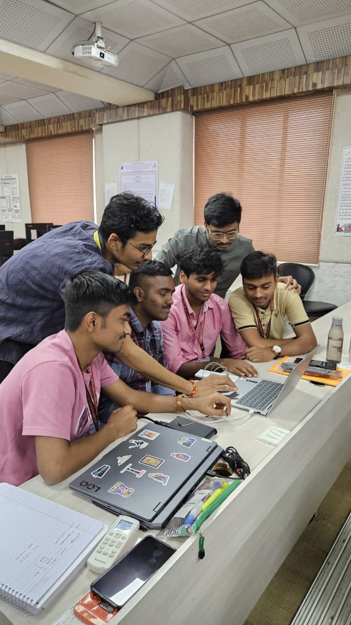 Students debugging a project together around a laptop in the lab