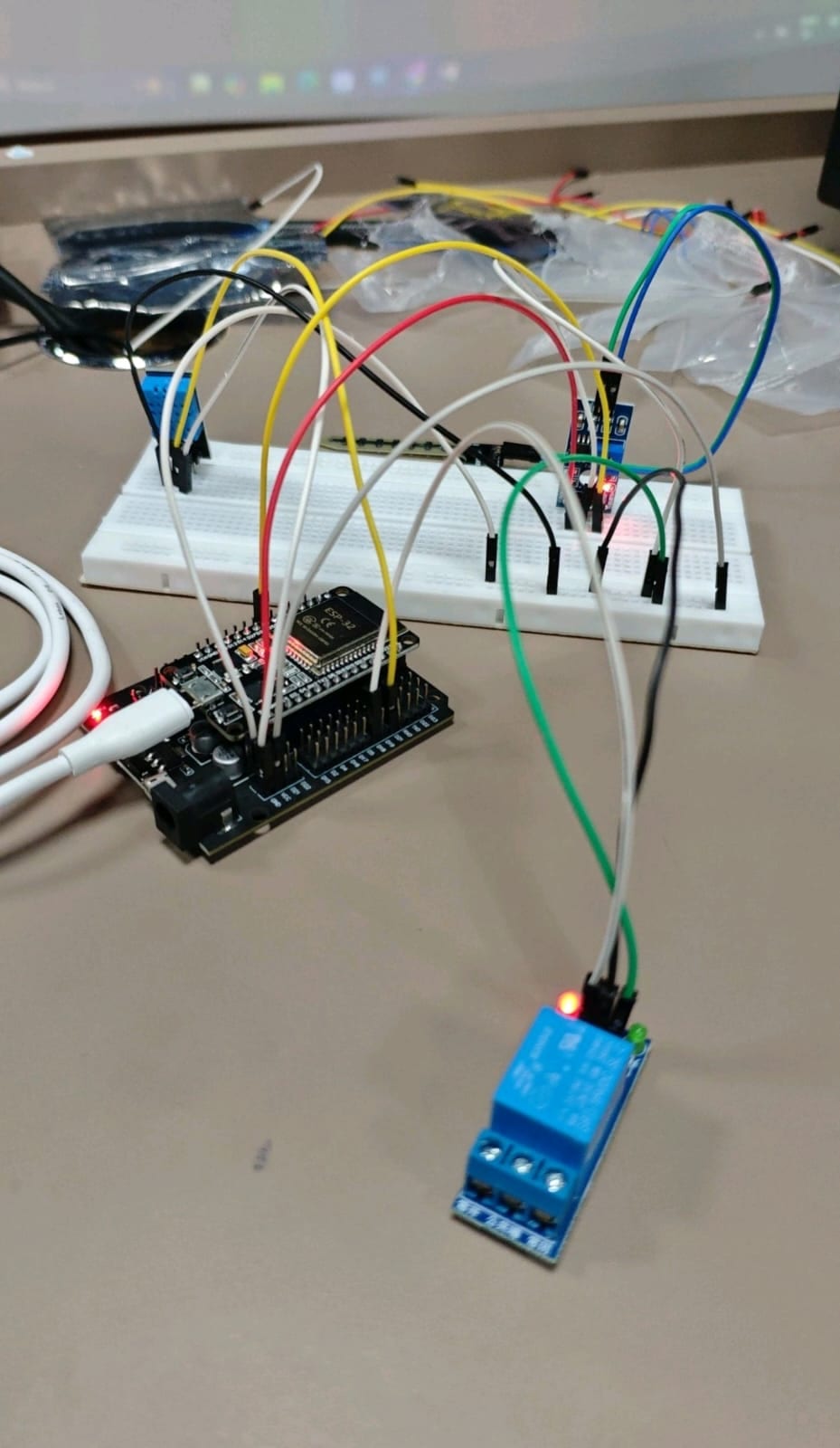 Live ESP32 breadboard build with jumper wires and a glowing relay